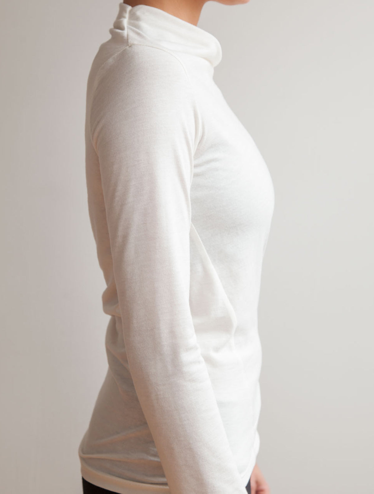 side view of model wearing simulacra's white Long Sleeve Twist Top