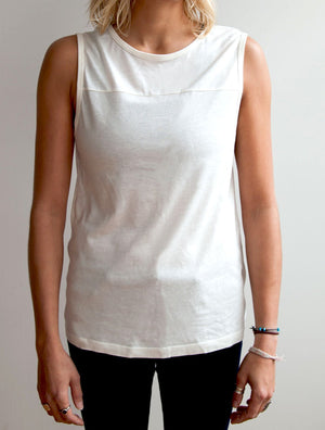 Front view of model wearing simulacra's womens organic cotton muscle tank in white