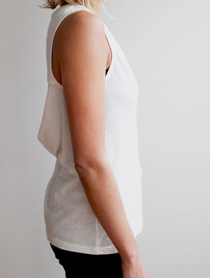 Right side view of model wearing simulacra's womens organic cotton muscle tank in white