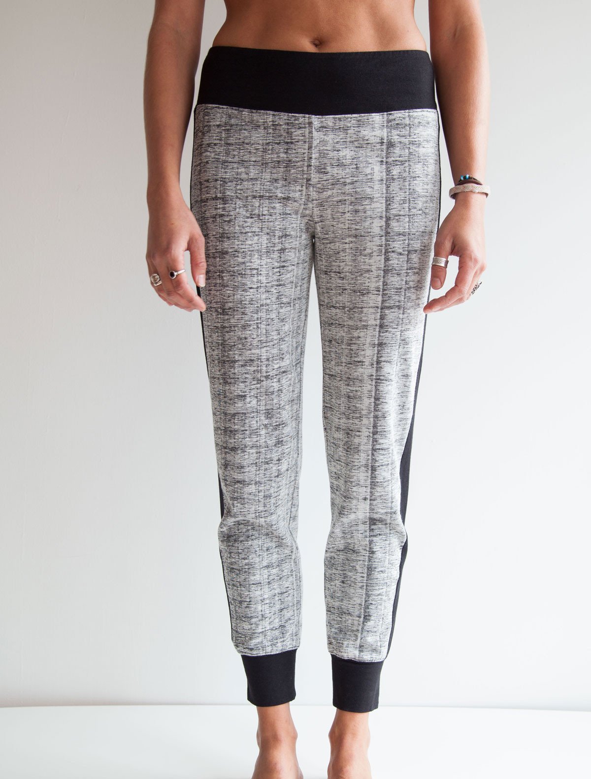 front view of female model wearing simulacra's patterned cropped joggers with a bare stomach to show off the high rise fit