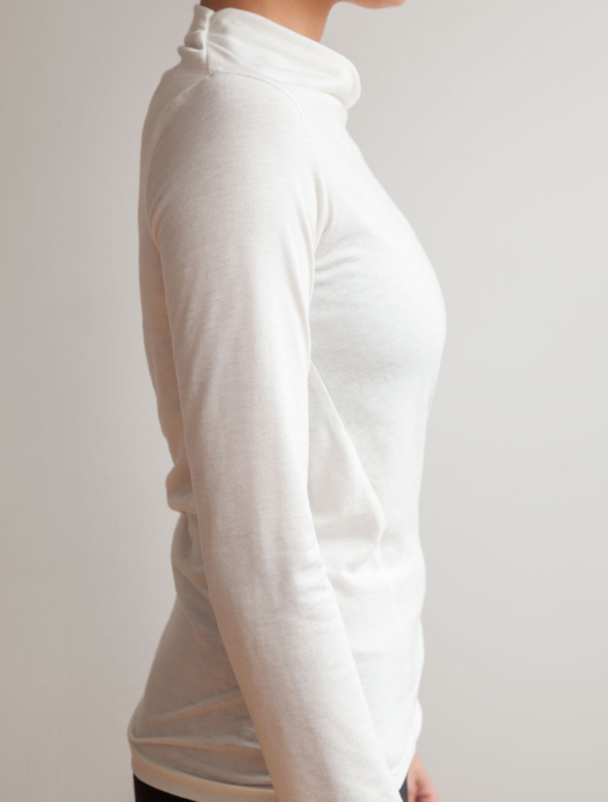 side view of model wearing simulacra's white Long Sleeve Twist Top 