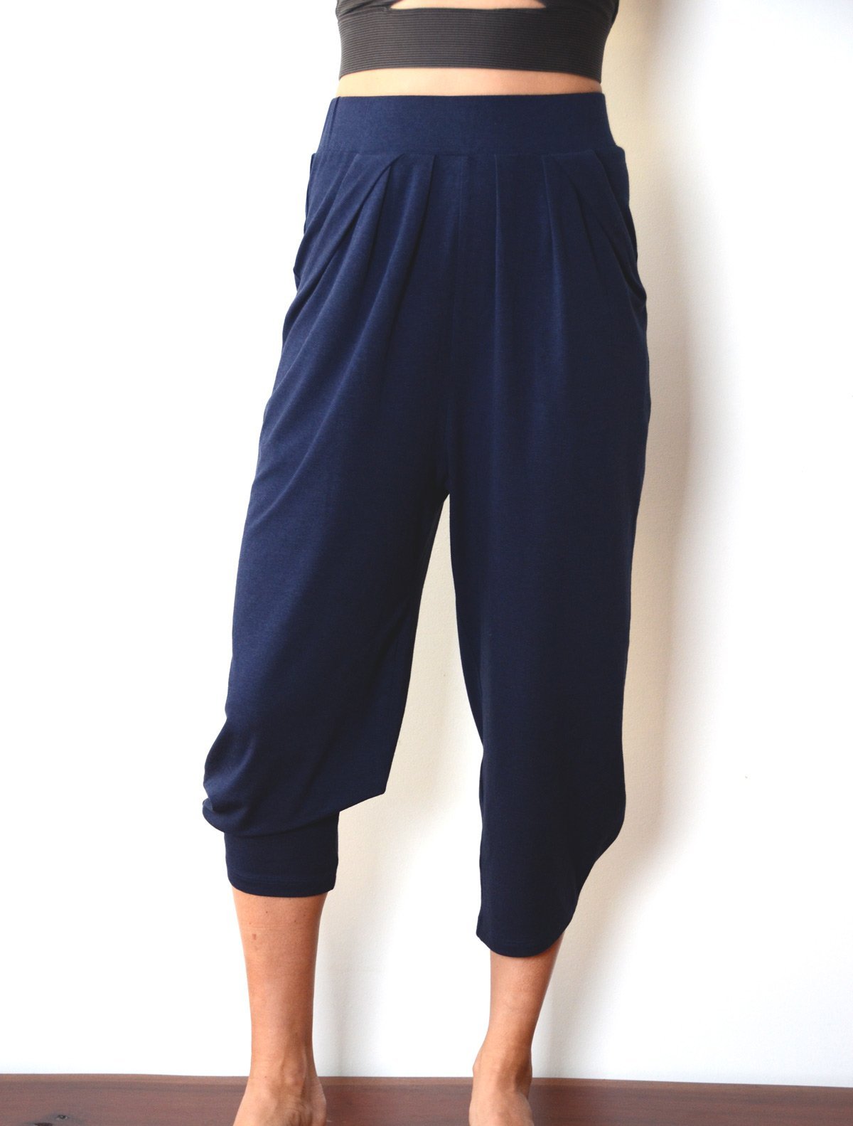 Front view of female model wearing simulacra's pleated drop crotch harem pants in blue