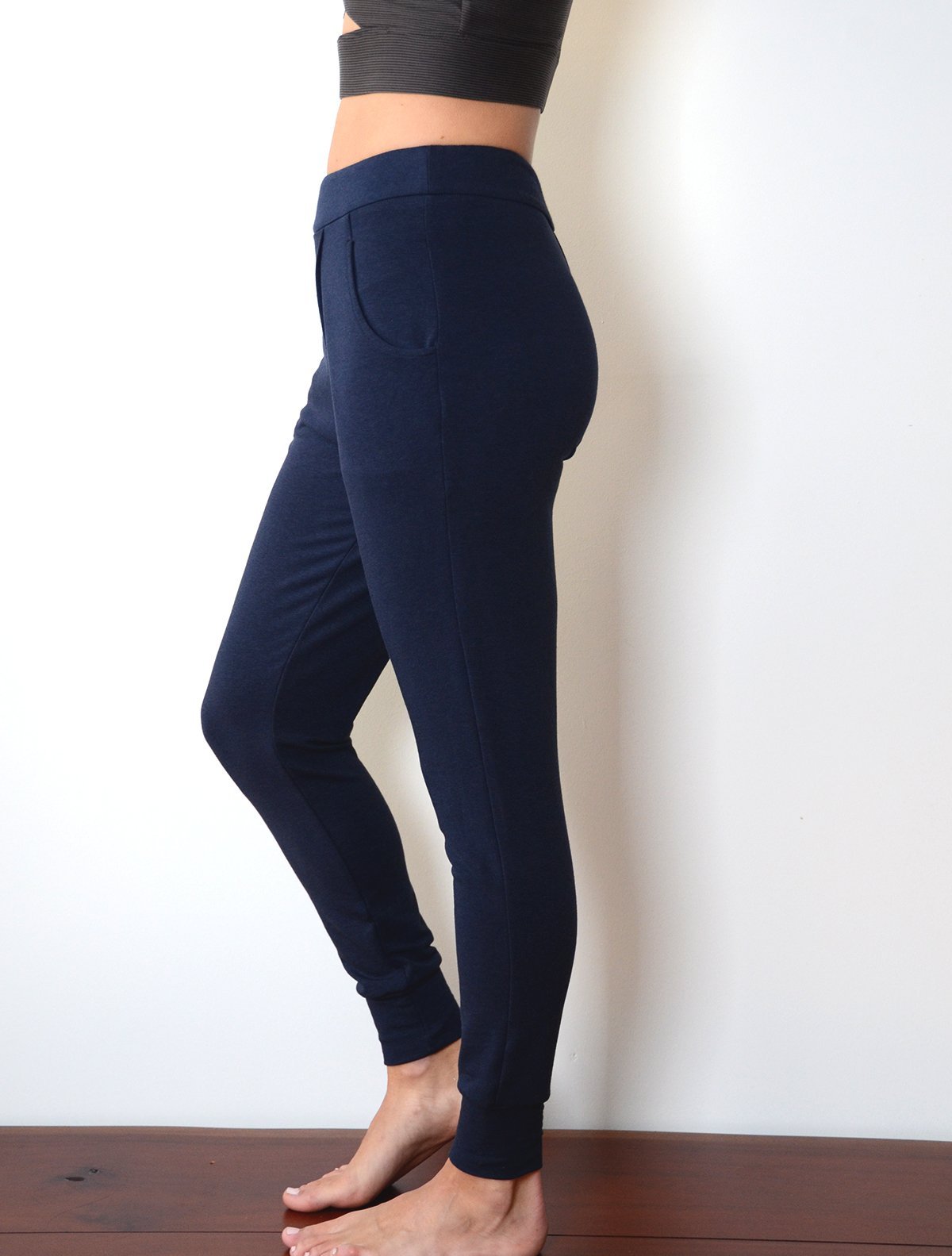 left side view of model wearing simulacra's navy blue french terry trouser pants with pockets