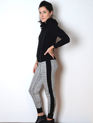 side view of female model wearing simulacra's patterned cropped joggers with the black cowl neck zip hoodie