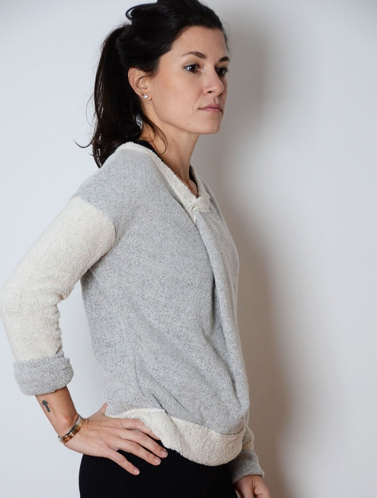 Side view of model wearing simulacra's women's 3-in-1 convertible  sweater in a v neck fold