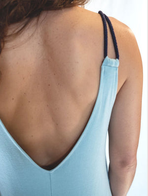 Closeup view of back of woman wearing simulacra's sleeveless loose jumpsuit in the color mint green