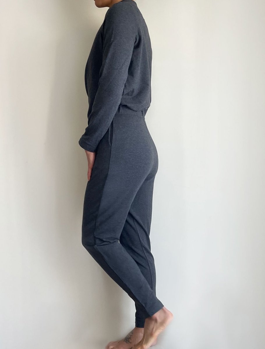 Left side view of model wearing simulacra's charcoal grey women's winter jumpsuit